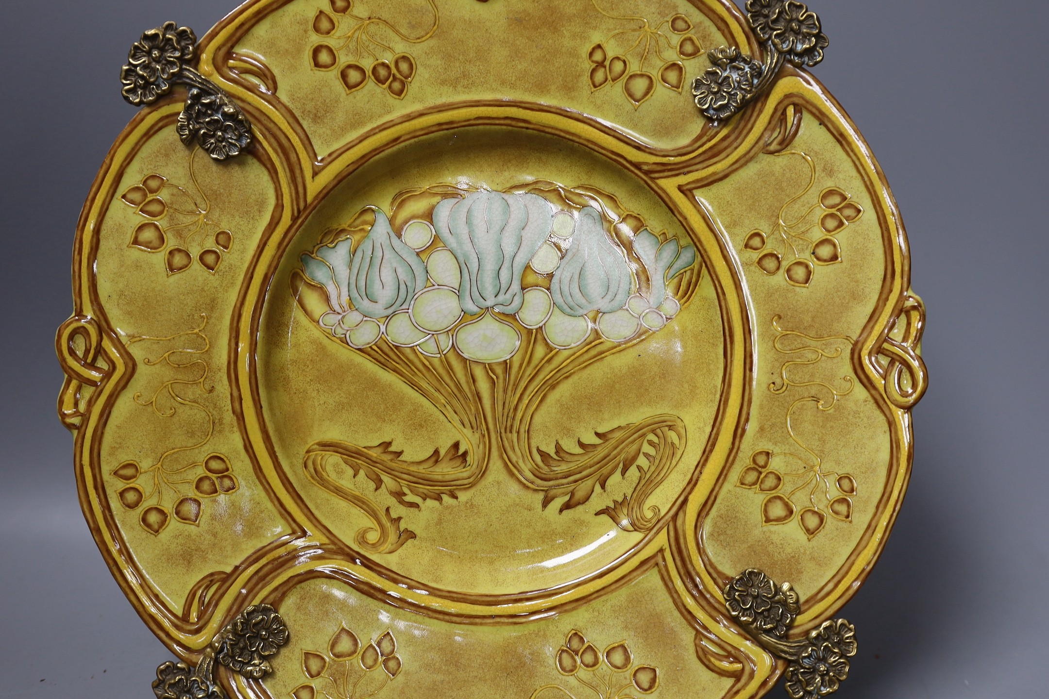 Two Continental Art Nouveau style plaques and a brass mounted dish, dish 31.5 cms diameter.